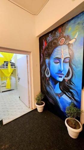 a painting on the wall of a room with plants at Elephant House Boutique Stays- BHU- BLW in Varanasi