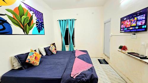 a room with a bed with pillows and a tv at Elephant House Boutique Stays- BHU- BLW in Varanasi