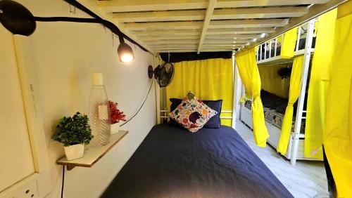 a bed in a small room with yellow curtains at Elephant House Boutique Stays- BHU- BLW in Varanasi