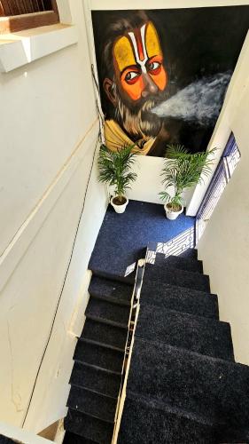 a staircase with a painting of a monkey on the wall at Elephant House Boutique Stays- BHU- BLW in Varanasi