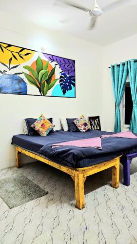 a bed in a room with a painting on the wall at Elephant House Boutique Stays- BHU- BLW in Varanasi
