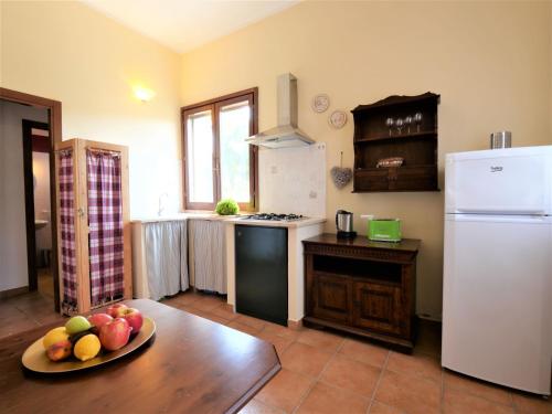 a kitchen with a refrigerator and a table with fruit on it at Holiday Home Oca by Interhome in Sticciano
