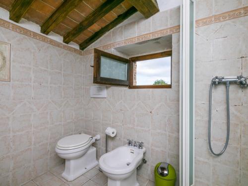 a bathroom with a toilet and a sink at Holiday Home Bellavista - Villi by Interhome in Montieri