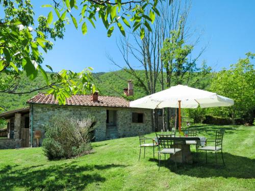 a table and chairs with an umbrella in front of a house at Holiday Home Bellavista - Villi by Interhome in Montieri