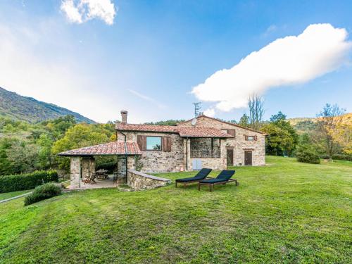 a stone house with a bench in the yard at Holiday Home Bellavista - Villi by Interhome in Montieri