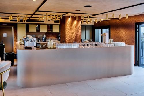 a bar in a restaurant with tables and chairs at Novotel Valencia Lavant in Valencia