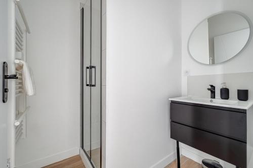 une salle de bain avec un lavabo et un miroir dans l'établissement Appartement spacieux et lumineux en plein centre, à Saint-Étienne