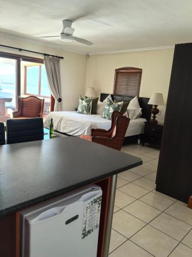 a living room with a bed and a living room with a couch at Berg en Zee Guesthouse in Gordonʼs Bay