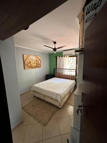 a bedroom with a bed with green walls and a ceiling at Sítio Mairiporã-Piscina Aquecida in Mairiporã