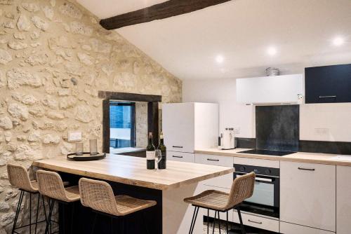 une cuisine avec un comptoir, des chaises et une table dans l'établissement Domaine Baudon, situé au coeur des vignes, à Montagne