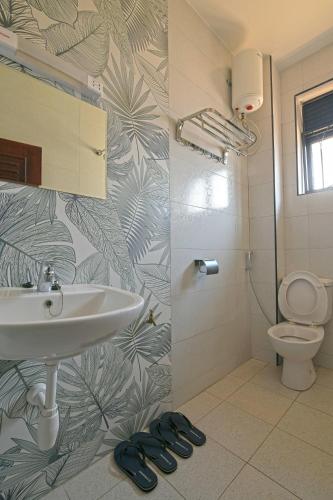 a bathroom with a sink and a toilet at Aqueduct 1359 Hotel Apartments in Kampala