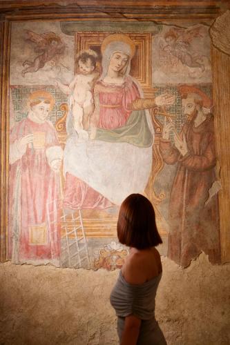 a young girl looking at a painting on a wall at Castello Di Postignano Relais in Sellano