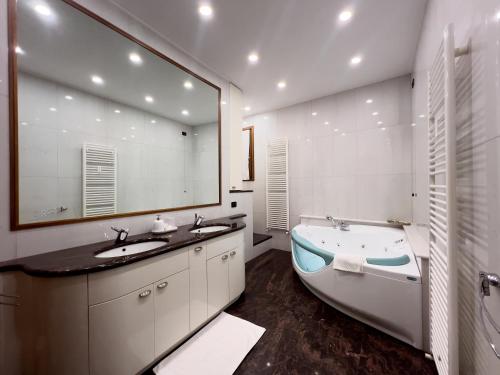 a bathroom with a tub and a large mirror at Nama Boutique Residence in Venice