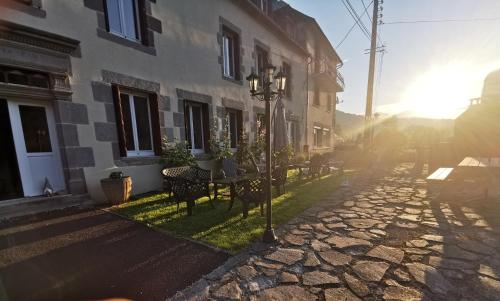 a street with tables and chairs in front of a building at Au coeur du Volcantal in Laveissière