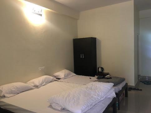 two twin beds in a room with a black cabinet at LAKE VIEW Chikkamagaluru in Chikmagalūr