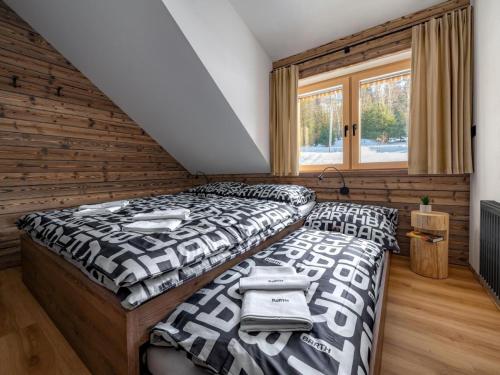 Horní MoravaにあるApartment Dolní Morava-6 by Interhomeの木製の壁の部屋にベッドが2つある