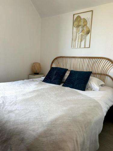 a bedroom with a large white bed with blue pillows at Charlotte Lodge-House 4 pers-wifi-parking-Dinard in Dinard