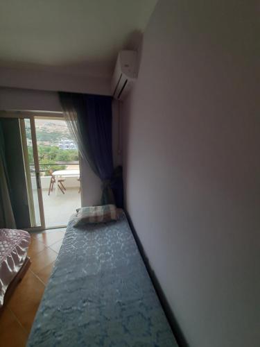 a bedroom with a bed and a window with a view at Dimitris Himara's apartment in Polisi i Vogël