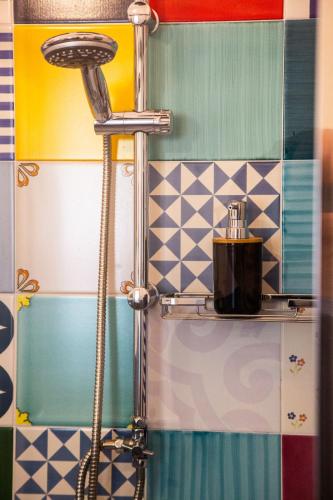 a shower in a bathroom with colorful tiles at B&B La Milanese in Maratea