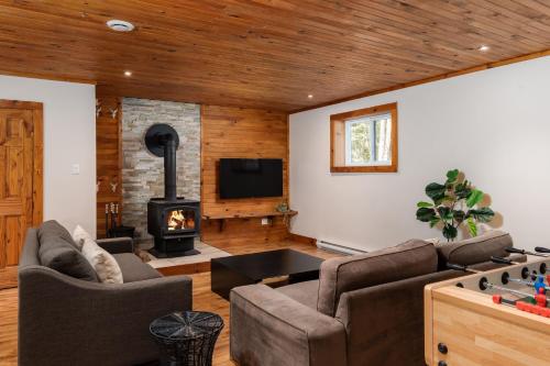a living room with a couch and a fireplace at Chalet La Canopée -familial par excellence MontBlanc in Mont-Blanc