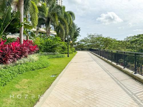 a walkway in a park with palm trees and a fence at 3BR3B Hozem JB1306 Apartment Forest City in Gelang Patah