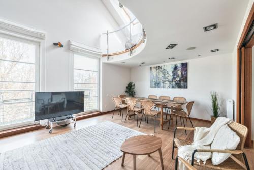 a dining room with a table and chairs and a tv at Kamienica Sopocka by NorthSide Apartments in Sopot