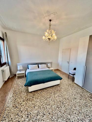 a bedroom with a large bed and a chandelier at Murano Canal View in Murano