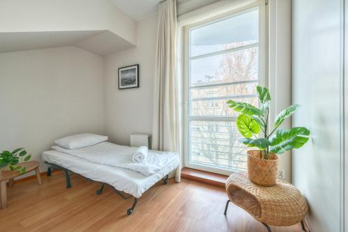 a room with a bed and a potted plant at Kamienica Sopocka by NorthSide Apartments in Sopot