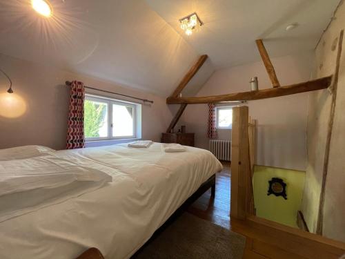 une chambre avec un grand lit blanc et une fenêtre dans l'établissement gîte des martinets and its corner of greenery, à Amboise