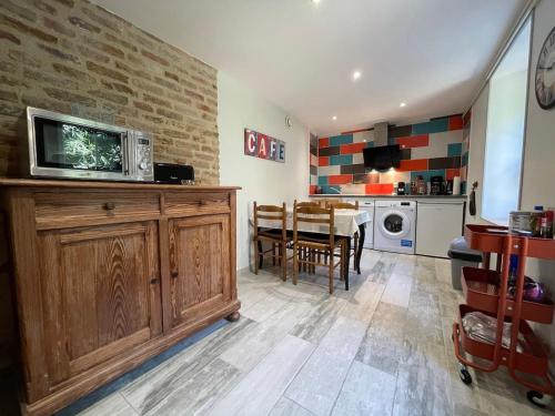 une cuisine avec une table et un micro-ondes sur un meuble en bois dans l'établissement gîte des martinets and its corner of greenery, à Amboise