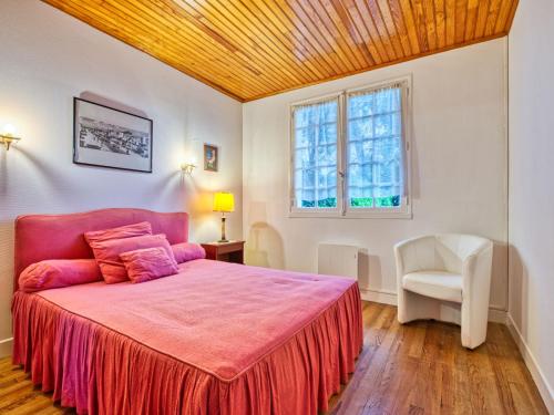 - une chambre avec un lit rose et une chaise blanche dans l'établissement Holiday Home L'étang by Interhome, à Lacanau
