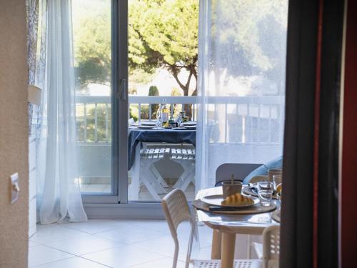 une table et des chaises dans une pièce avec une fenêtre dans l'établissement Studio La Frégate-15 by Interhome, au Grau-du-Roi