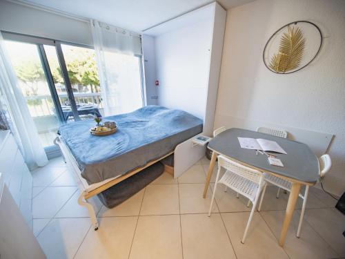 une petite chambre avec un lit et une table dans l'établissement Studio La Frégate-15 by Interhome, au Grau-du-Roi