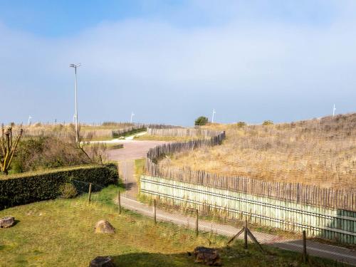 une clôture sur une colline avec une route et un champ dans l'établissement Apartment Front de Mer-9 by Interhome, à Cabourg