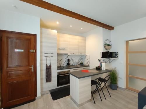 une cuisine avec un comptoir, une table et des chaises dans l'établissement Coquet 2 pièces entièrement rénové et climatisé, à Cannes