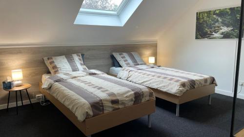a bedroom with two beds and a window at B&B Haus Kristal in Walsdorf
