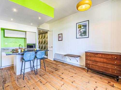 une cuisine avec un comptoir et deux tabourets bleus dans l'établissement Apartment Kériolet by Interhome, à Auray