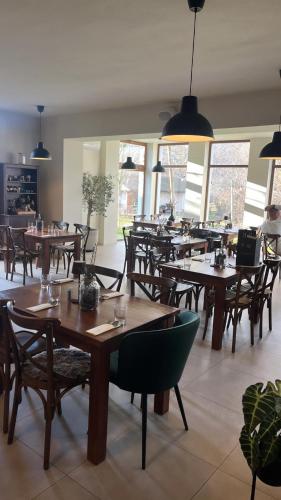 an empty restaurant with wooden tables and chairs at Penzion Platan in Ňárad