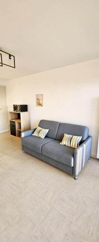 - un canapé bleu dans le salon dans l'établissement Face Mer, à Fort-Mahon-Plage