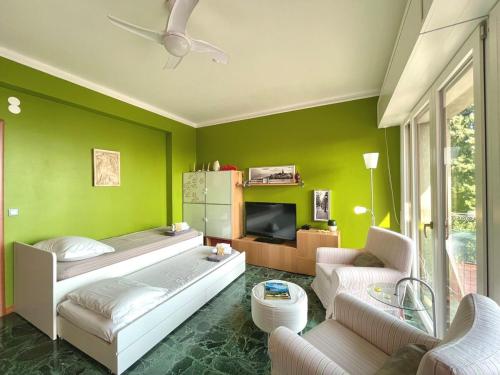 a room with two beds and a green wall at D1MORA LagoBlu - private beach and lake view in Toscolano Maderno
