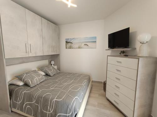 - une chambre avec un lit et une commode avec une télévision dans l'établissement Coquet 2 pièces entièrement rénové et climatisé, à Cannes