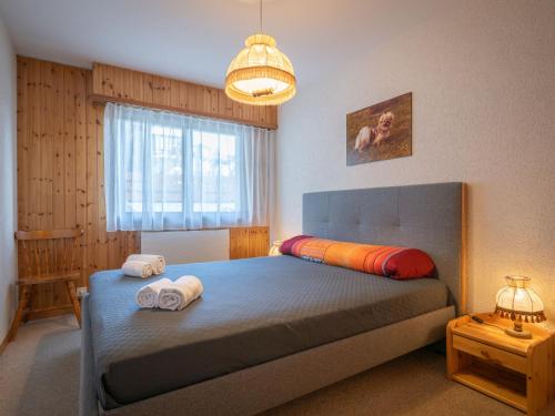 a bedroom with a bed with two towels on it at Apartment Austral 105 by Interhome in Ovronnaz