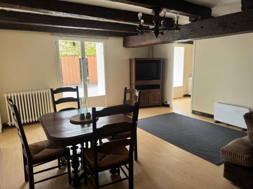 a living room with a table and a tv at Comfortable countryside gite access to jacuzzi in Asnois