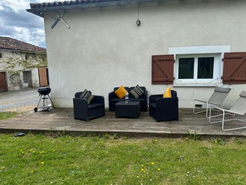 a patio with couches and chairs on a deck at Comfortable countryside gite access to jacuzzi in Asnois