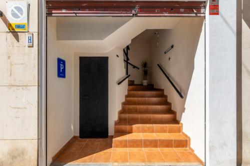 a stairway with a black door and a stair case at Pensión Plaza América in Alicante