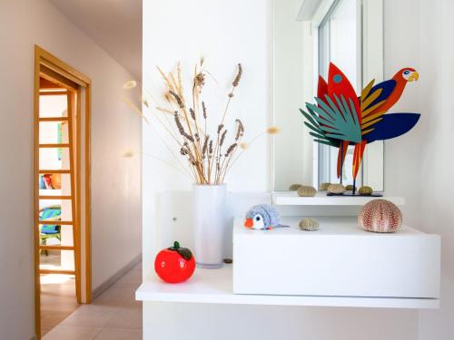 une pièce avec une étagère blanche avec un oiseau dessus dans l'établissement Holiday Home Le Paradou by Interhome, à La Bernerie-en-Retz