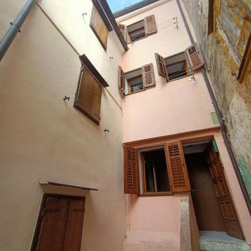 an apartment building with wooden doors and windows at B&B Raggio di sole in Muggia