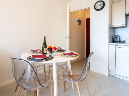 - une table blanche avec des chaises et une bouteille de vin dans l'établissement Apartment Plein Sud-18 by Interhome, à Cabourg