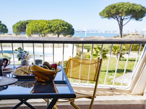une table avec un bol de fruits sur un balcon dans l'établissement Studio Escale Plage-3 by Interhome, au Grau-du-Roi