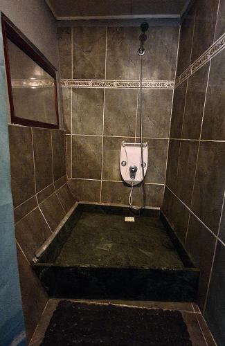 a bathroom with a urinal on a tiled wall at FunHouse in Bucharest